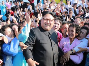 This undated picture released on September 12, 2017 shows North Korean leader Kim Jong-Un (C) attending a photo session with teachers who volunteered to work at branch schools on islands and schools in forefront line and mountainous areas, in Pyongyang.