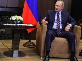 Russian President Vladimir Putin (R) talks with Lebanese Prime Minister Saad Hariri during a meeting in Sochi on September 13, 2017.