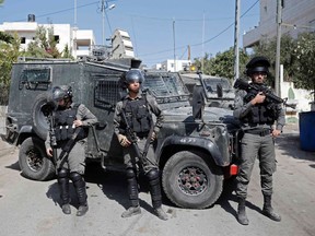 Israeli security forces stand guard in front of the house of a Palestinian who opened fire on security personnel before being shot dead during a fatal attack at the entrance to the Israeli settlement of Har Adar, in the West Bank village of Beit Surik on September 26, 2017.