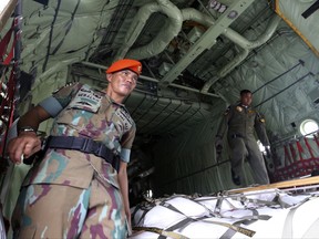 Indonesia Air Force soldiers load relief supplies for Rohingya refugees before its departure at Halim Perdanakusuma air base in Jakarta, Indonesia, Wednesday, Sept. 13, 2017. Four Hercules planes carrying 34 tons of aid for Rohingya refugees have departed for Bangladesh from an air force base in the Indonesian capital.(AP Photo/Achmad Ibrahim)