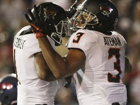 Oklahoma State wide receiver Jalen McCleskey, left, celebrates with Oklahoma State wide receiver Marcell Ateman after Ateman scored a touchdown against South Alabama during the first half of an NCAA college football game, Friday, Sept. 8, 2017, in Mobile, Ala. (AP Photo/Dan Anderson)