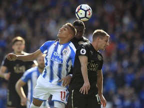 Huddersfield Town's Abdelhamid Sabiri, left, battles with Leicester City's Marc Albrighton, right and Wilfred Ndidi during the Premier League soccer match between Huddersfield and Leicester City,  at the John Smith's Stadium, in Huddersfield, England, Saturday, Sept. 16, 2017. (Mike Egerton/PA via AP)