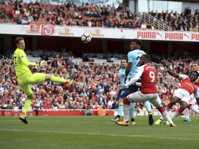 Arsenal's Danny Welbeck, right, scores his side's first goal of the game during the English Premier League soccer match between Arsenal and Bournemouth, at the Emirates Stadium, in London, Saturday Sept. 9, 2017. (John Walton/PA via AP)