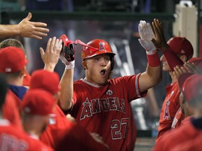 Los Angeles Angels' Mike Trout is congratulated by teammates after scoring on a double by Kole Calhoun during the first inning of a baseball game against the Houston Astros, Wednesday, Sept. 13, 2017, in Anaheim, Calif. (AP Photo/Mark J. Terrill)