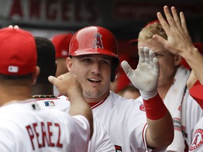 Los Angeles Angels' Mike Trout celebrates in the dugout after scoring on a double by Albert Pujols during the first inning of a baseball game against the Cleveland Indians in Anaheim, Calif., Thursday, Sept. 21, 2017. (AP Photo/Chris Carlson)
