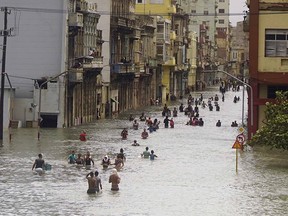 People move through flooded streets in Havana after the passage of Hurricane Irma, in Cuba, Sunday, Sept. 10, 2017.