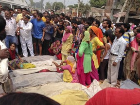 Villagers protest with dead bodies of victims of a boat capsize as they block traffic on the Delhi-Saharanpur highway at Katha village near Baghpat town in Uttar Pradesh state, India, Thursday, Sept.14, 2017. A boat crowded with construction workers capsized in the Yamuna River early Thursday and nineteen bodies have been pulled out of the river so far. (AP Photo/Altaf Qadri)