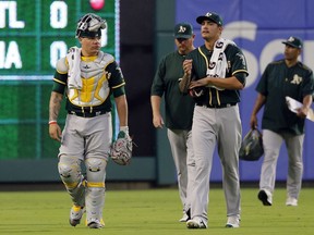 Oakland Athletics catcher Bruce Maxwell (13) and starting pitcher Sean Manaea, right front, walk from the bullpen for the first inning of a baseball game against the Texas Rangers  Thursday, Sept. 28, 2017, in Arlington, Texas. (AP Photo/Tony Gutierrez)