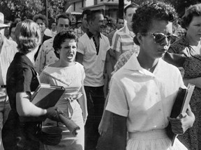 FILE - In this Sept. 4, 1957, file photo, students of Central High School in Little Rock, Ark., including Hazel Bryan, shout insults at Elizabeth Eckford as she calmly walks toward a line of National Guardsmen. The Guardsmen blocked the main entrance and would not let her enter. Monday, Sept. 25, 2017, marks 60 years since the Little Rock Nine first entered the school for classes. (Will Counts/Arkansas Democrat-Gazette via AP, File)