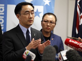 Jian Yang, left, a New Zealand lawmaker who was born in China, answers questions at a news conference in Auckland, New Zealand, Wednesday, Sept. 13, 2017. Yang says he's loyal to his new home after media reported he'd spent a decade at top Chinese military colleges and was investigated by New Zealand's intelligence agency. (Dean Purcell/New Zealand Herald via AP)