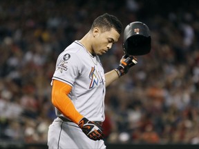 Miami Marlins' Giancarlo Stanton throws his helmet after striking out against the Arizona Diamondbacks to end the top of the second inning of a baseball game, Friday, Sept. 22, 2017, in Phoenix. (AP Photo/Ralph Freso)