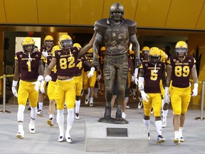 Arizona State's Josh Pokraka (82) and teammates touch the Pat Tillman statue before an NCAA college football game against New Mexico State, Thursday, Aug. 31, 2017, in Tempe, Ariz.. (AP Photo/Rick Scuteri)