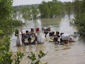 CORRECTS DAY AND DATE - A Rohingya family reaches the Bangladesh border after crossing a creek of the Naf river on the border with Myanmmar, in Cox's Bazar's Teknaf area, Tuesday, Sept. 5, 2017. (AP Photo/Bernat Armangue)