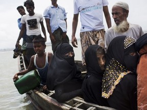 Myanmar's Rohingya ethnic minority use a local boat to cross a stream after crossing over to the Bangladesh side of the border near Cox's Bazar's Dakhinpara area, Saturday, Sept. 2, 2017. Thousands of Rohingya Muslims are pouring into Bangladesh, part of an exodus of the beleaguered ethnic group from neighboring Myanmar that began when violence erupted there on August 25. (AP Photo/Bernat Armangue)