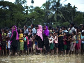 Rohingya Muslims, who crossed over recently from Myanmar into Bangladesh, stand in a queue to receive food being distributed near Balukhali refugee camp in Cox's Bazar, Bangladesh, Tuesday, Sept. 19, 2017. More than 500,000 Rohingya Muslims have fled to neighboring Bangladesh in the past year, most of them in the last three weeks, after security forces and allied mobs retaliated  to a series of attacks by Muslim militants last month by burning down thousands of Rohingya homes in the predominantly Buddhist nation. (AP Photo/Bernat Armangue)