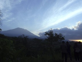 Mount Agung is seen at sunrise from an observation point which is about 12 kilometer (7.4 miles) away from the volcano in Karangasem, Bali, Indonesia, Thursday, Sept. 28, 2017. The exodus from the menacing volcano on the Indonesian tourist island is nearing 100,000 people, a disaster official said Wednesday, as hundreds of tremors from the mountain are recorded daily. (AP Photo/Firdia Lisnawati)