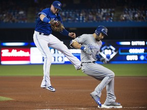Eric Hosmer of the Kansas City Royals is safe at first after a throwing error by Blue Jays third baseman Josh Donaldson (not shown) forces first baseman Justin Smoak off the bag during fourth inning action in Toronto on Thursday night.