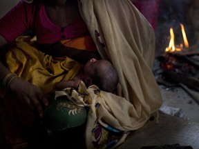 In this Thursday, Sept. 7, 2017 photo, 25-year-old Rohingya Muslim woman Zahida Begum cradles her few-hours-old son who she gave birth to alone in the toilet outside the room, at Kutupalong refugee camp, Bangladesh. Begum had crossed into Bangladesh on Sept. 1, with her two young sons, husband and mother, fleeing shootings and arson attacks by Myanmar army soldiers and local monks. Through hours of walking through this massive refugee camp, set up in the early 90s to accommodate the first waves of Rohingya Muslim refugees who started escaping convulsions of violence and persecution in Myanmar, Associated Press reporters could not spot a single doctor. There are no clinics or pharmacies or even basic first aid centers. (AP Photo/Bernat Armangue)
