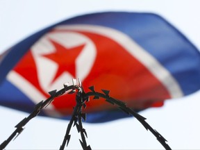 In this March 9, 2017, file photo, the North Korean flag is seen behind razor wire on top of a wall at the North Korean Embassy in Kuala Lumpur, Malaysia. Malaysia has banned its citizens from traveling to North Korea as the country faces increasing diplomatic pressure over its weapons programs. The foreign ministry announced the ban in a statement Thursday, Sept. 28, 2017, and said it would last until further notice. (AP Photo/Vincent Thian, File)