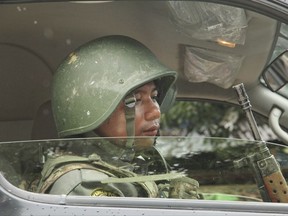 A Myanmar Border Guard Police officer sits inside a police van to guard the journalists who are taking part in a government organized media trip in Buthidaung, northern Rakhine state of Myanmar, on Wednesday, Sept. 6, 2017. Myanmar leader Aung San Suu Kyi's top security adviser sought to counter the storm of criticism the government is facing from around the world over alleged army abuses against ethnic minority Rohingya, asserting that security forces were acting with restraint in pursuing "terrorists." (AP Photo)