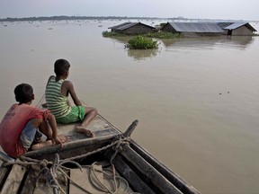 In this Aug. 15, 2017, file photo, flood affected villagers travel by boat in floodwaters in Morigaon district, east of Gauhati, northeastern state of Assam. This week's flooding in Houston is unprecedented, but such devastation is chronic across South Asia. Experts say local officials are ignoring dangers and pursuing development plans that only increase the risk of flood-related death and destruction as annual monsoon rains challenge cities to cope. (AP Photo/Anupam Nath, File)