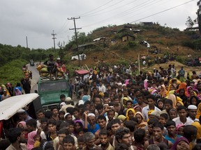 FILE - In this Sunday, Sept. 3, 2017, file photo, Myanmar's Rohingya ethnic minority refugees scuffle for food rations distributed by Bangladeshi volunteers near Cox's Bazar's Gundum area, Bangladesh. The U.N. refugee agency is reporting a surge in the number of Rohingya Muslims who have crossed into Bangladesh from Myanmar, with an estimated 270,000 arriving in the last two weeks. (AP Photo/Bernat Armangue, File)