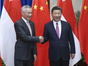 Singapore Prime Minister Lee Hsien Loong, left, shakes hands with China's President Xi Jinping before a meeting at The Great Hall Of The People, Wednesday, Sept. 20, 2017, in Beijing. (Lintao Zhang/Pool Photo via AP)
