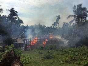 In this Thursday, Sept. 7, 2017, file photo, fire engulfs homes in the Gawdu Zara village, northern Rakhine state, Myanmar. Two weeks after violence in western Myanmar caused minority Rohingya Muslims to flee into neighboring Bangladesh, global reactions to the crisis have included anger, protests in Islamic country capitals and dismissals by Myanmar authorities. (AP Photo, File)