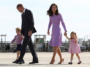 In this Friday, July 21, 2017 file photo Britain's Prince William and his wife Kate, the Duchess of Cambridge and their children Prince George and Princess Charlotte on their way to board a plane in Hamburg, Germany