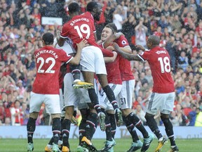 Manchester United players celebrate after Manchester United's Antonio Valencia, hidden, scored his sides first goal during the English Premier League soccer match between Manchester United and Everton at Old Trafford in Manchester, England, Sunday, Sept. 17, 2017. (AP Photo/Rui Vieira)