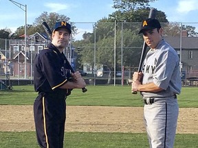 In this Tuesday, Sept. 26, 2017 photo provided by the Rhode Island World War I Centennial Commission, U.S. Navy Cmdr. Justin Dorgan, left, and U.S Army Maj. Ricky Tang, right, pose in replica World War I-era flannel baseball uniforms during practice at Cardines Field in Newport, R.I. The U.S. Naval War College is honoring the centennial of America's involvement in the war by playing a baseball game by century-old rules on Friday in Newport. (Matthew McCoy/Rhode Island World War I Centennial Commission via AP)