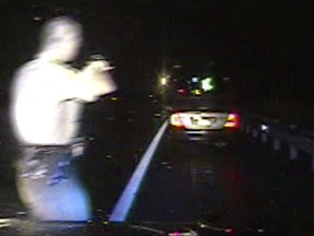 In this Aug. 8, 2017, still frame from dashboard camera video released by the Vermont State Police, Trooper Justin Thompson, left, points his weapon at a car that had been driven by Rabbi Berl Fink, of of Brooklyn, N.Y., during a traffic stop in Thetford, Vt. An internal investigation of the nighttime traffic stop of the rabbi, who was ordered at gunpoint to lie on the ground and his family handcuffed after he failed to stop, has cleared the trooper of wrongdoing. State police officials said Friday, Sept. 29, 2017, that Thompson clocked the vehicle at 83 miles per hour on Interstate 91, and he tried to stop the vehicle with lights and siren but it failed to stop for 4.5 miles. (Vermont State Police via AP)