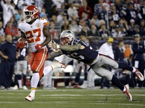 Kansas City Chiefs running back Kareem Hunt eludes New England Patriots defensive end Cassius Marsh as he completes a touchdown after catching a pass from Alex Smith during the second half of Thursday's NFL opener