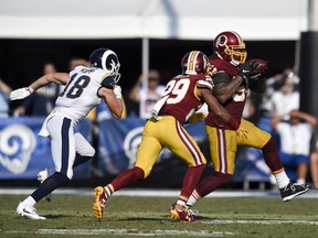 Washington Redskins inside linebacker Mason Foster, right, intercepts a pass intended for Los Angeles Rams wide receiver Cooper Kupp, left, as Kendall Fuller looks on during the second half of an NFL football game Sunday, Sept. 17, 2017, in Los Angeles. (AP Photo/Kelvin Kuo)
