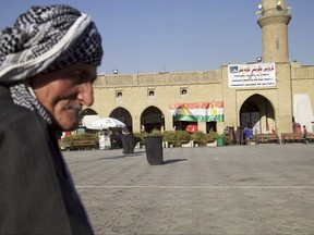 In this Thursday, Aug. 24, 2017 photo, an elderly man sits in the center of Irbil near a campaign poster urging people to vote yes in the upcoming poll on independence from Iraq. Despite calls from Baghdad and the United States to postpone the vote, Iraq's semi-autonomous Kurdish region is pressing ahead with plans to hold a referendum on independence September 25. Some officials within Iraq's Kurdistan Regional Government describe the vote as a step in pursuit of self-determination, but the lead up to the planned referendum has highlighted the region's lingering divisions and economic deficiencies.(AP Photo/Balint Szlanko)