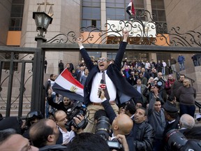 FILE - In this Jan. 16, 2017 file photo, lawyer and former presidential candidate Khaled Ali, center, celebrates with other lawyers after winning a landmark case against the government, blocking its attempts to hand over control of two strategic Red Sea islands to Saudi Arabia, in Cairo, Egypt. On Monday, Sept. 25, 2017, an Egyptian court sentenced Ali, a prominent opposition leader widely expected to run against President Abdel-Fattah el-Sissi in next year's elections, to three months in prison over a charge of offending public morals for making an obscene finger gesture. (AP Photo/Amr Nabil, File)