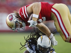 San Francisco 49ers tight end Logan Paulsen, top, is tackled by Los Angeles Chargers cornerback Brandon Stewart after a catch during the first half of a preseason NFL football game Thursday, Aug. 31, 2017, in Santa Clara, Calif. (AP Photo/John Hefti)