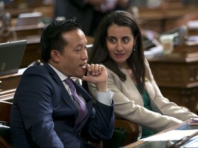 Assemblyman David Chiu, D-San Francisco talks with his seat mate, Assemblywoman Monique Limon, D-Goleta, after the Assembly approved Chiu's immigration bill, Monday, Sept. 11, 2017, in Sacramento, Calif. By a 49-18 vote the Assembly approved AB291 that prohibits landlords from disclosing the immigration status of tenants or threatening to report tenants to immigration authorities. (AP Photo/Rich Pedroncelli)