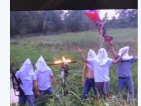 In this screen shot image taken from Twitter, five men wearing white hoods wave a Confederate flag next to a burning cross. The principal of Creston Community High School in southern Iowa says the school has disciplined several students who appeared in the photo, which circulated on social media, after officials became aware of it on Wednesday morning, Sept. 6, 2017. (Twitter via AP)