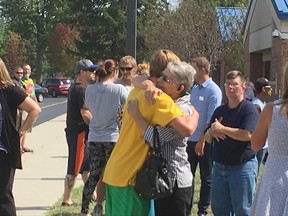 In this photo courtesy of WAND-TV people embrace outside Mattoon High School after a shooting incident in the school Wednesday, Sept. 20, 2017, in Mattoon, Ill. Police in central Illinois city say a teacher subdued a male student who shot and wounded another student in a high school cafeteria, and the suspect is in custody. Officials said the injured student is in stable condition at a local hospital. (Photo courtesy of WAND TV via AP)