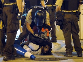 FILE - In this Sept. 17, 2017 file photo, police arrest a man as demonstrators march in response to a not guilty verdict in the trial of former St. Louis police officer Jason Stockley, in St. Louis. Stockley was acquitted in the 2011 killing of a black man following a high-speed chase. St. Louis Mayor Lyda Krewson and Interim Police Chief Lawrence O'Toole called for the U.S. attorney's office to investigate allegations of police misconduct during the protests on Wednesday, Sept. 27, 2017. (AP Photo/Jeff Roberson File)