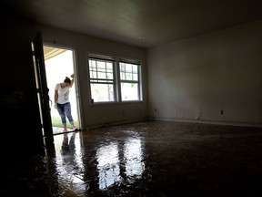 FILE - In this Aug. 31, 2017 file photo, Alejandra Castillo takes a break from carrying water-soaked items out of her family's home after flood waters receded in Houston. Experts say Harvey's filthy floodwaters pose significant dangers to human safety and the environment that will remain even after levels drop far enough that southeastern Texas residents no longer fear for their lives. (AP Photo/Charlie Riedel, File)