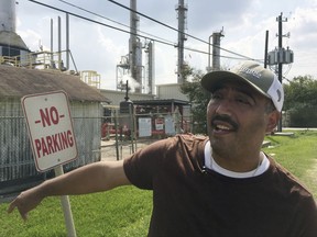 In this Sept. 2, 2017 photo, community environmental activist Juan Flores talks a reporter in Galena Park, Texas. Petrochemical corridor residents say air that is bad enough on normal days got unbearable as Harvey crashed into the nation's fourth-largest city and then yielded the highest ozone pollution of the year anywhere in Texas. (AP Photo/Frank Bajak)