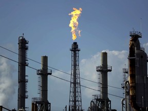 FILE - In this Thursday, Aug. 31, 2017, file photo, a flame burns at the Shell Deer Park oil refinery in Deer Park, Texas. Companies have reported that roughly two dozen storage tanks holding crude oil, gasoline and other fuels collapsed or otherwise failed during Harvey, spilling a combined 140,000 gallons of fuel, according to an Associated Press analysis of state and federal accident databases. Federal rules require companies to be prepared for spills, but don't require them to take any specific measures to secure the massive fuel storage tanks at refineries and oil production sites that are prone to float and break during floods. (AP Photo/Gregory Bull, File)