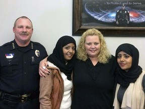 In this July 2017, photo provided by the Fargo Police Department, Police Chief David Todd, left, poses with, second from left, Sarah Hassan, Amber Hensley, center, and Leyla Hassan in Fargo, N.D. The three were involved in a verbal confrontation in a Walmart parking lot in Fargo, N.D. The dispute was quickly diffused just a few days later, with the women meeting in the police chief's office for hugs and a posed, smiling photo. It was one of the uglier incidents in Fargo race relations. Human rights groups in North Dakota are pushing for a comprehensive hate crimes law following the incident. (Fargo Police Department via AP)