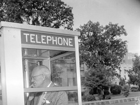 FILE - In this Sept. 20, 1957, file photo, Associated Press reporter Relman "Pat" Morin dictates a story from a telephone booth across the street from Central High School in Little Rock, Ark. Morin won his second Pulitzer Prize for his work at Little Rock. Monday, Sept. 25, 2017, is the 60th anniversary of the school's desegregation. (AP Photo/File)