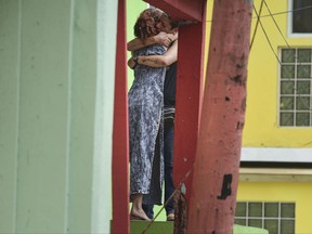 Residents at La Perla community in Old San Juan comfort one another as the community recovers from Hurricane Maria, in San Juan, Puerto Rico, Monday, Sept. 25, 2017. The island territory of more than 3 million U.S. citizens is reeling in the devastating wake of Hurricane Maria. (AP Photo/Carlos Giusti)