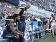 Seattle Seahawks defensive end Michael Bennett, left, sits during the singing of the national anthem as centre Justin Britt, right, stands next to him before a preseason game against the Kansas City Chiefs on Aug. 25.