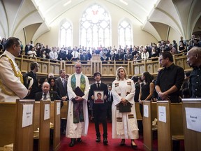 Attendees stand during a funeral service for Arnold Chan, former MP for Scarborough-Agincourt, in Toronto on Saturday, September 23, 2017. THE CANADIAN PRESS/Christopher Katsarov