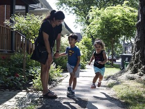 Serina Manek walks through her Leslieville neighbourhood in Toronto with her two children Mia (3), right, and Zane Partridge (5), right, on Wednesday, August 30, 2017. Manek says that the increase in condo development has not only made student placement in local schools more difficult, but traffic through local streets and alleyways have also increased. THE CANADIAN PRESS/Christopher Katsarov